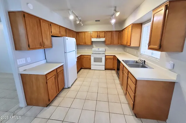 a kitchen with stainless steel appliances a stove a sink dishwasher and a refrigerator
