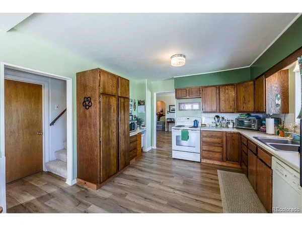 a kitchen with granite countertop wooden floors and stainless steel appliances