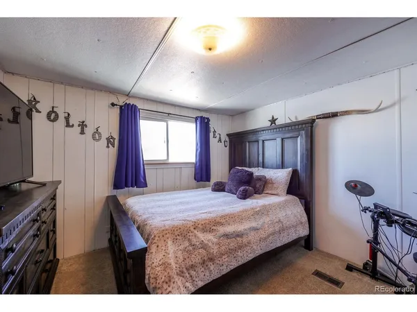 a bedroom with a bed window and a flat screen tv