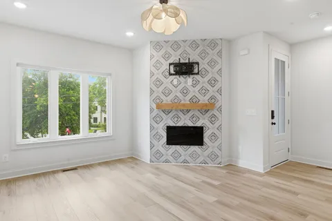 a view of an empty room with a fireplace and a window