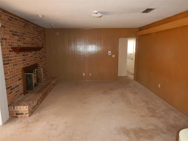 an empty room with fire place and windows
