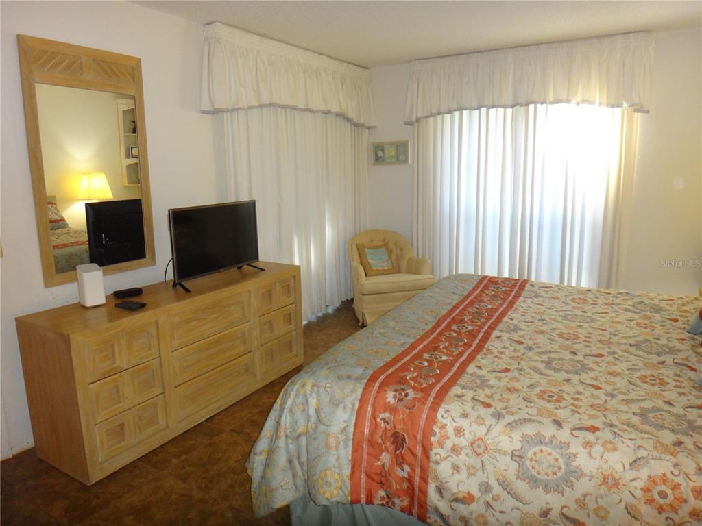 4493 Longmeadow, Unit 76 Sarasota, FL 34235 - Photo 16 of 24 a bedroom with a bed and a flat screen tv