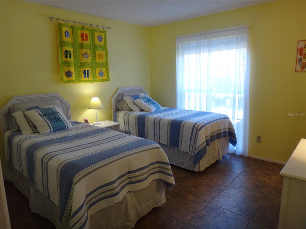 4493 Longmeadow, Unit 76 Sarasota, FL 34235 - Photo 19 of 24 a bedroom with two beds and wooden floor