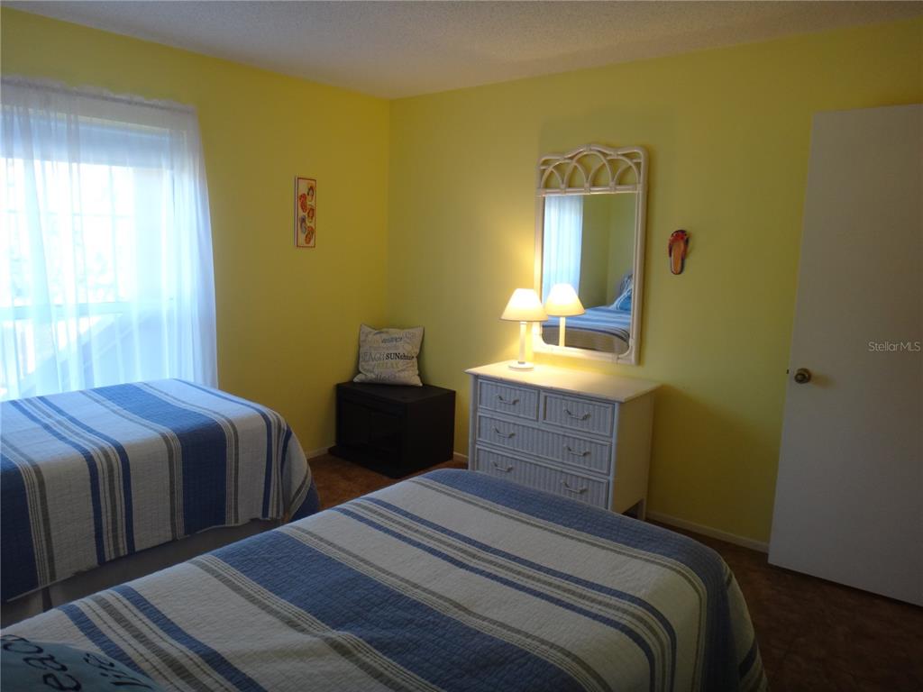 4493 Longmeadow, Unit 76 Sarasota, FL 34235 - Photo 20 of 24 a bedroom with two beds and a dresser
