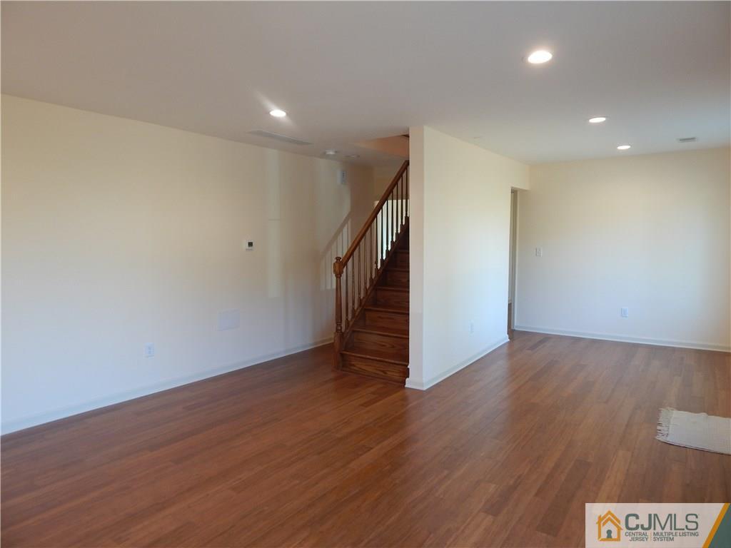 73 Idlewild Road Edison, NJ 08817 - Photo 8 of 21 a view of an empty room with wooden floor and stairs