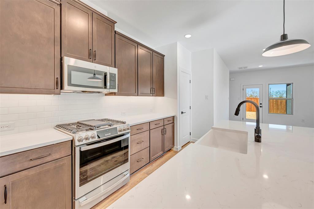 2217 Maple Ridge Drive Van Alstyne, TX 75495 - Photo 18 of 38 a kitchen with stainless steel appliances granite countertop a stove and a sink