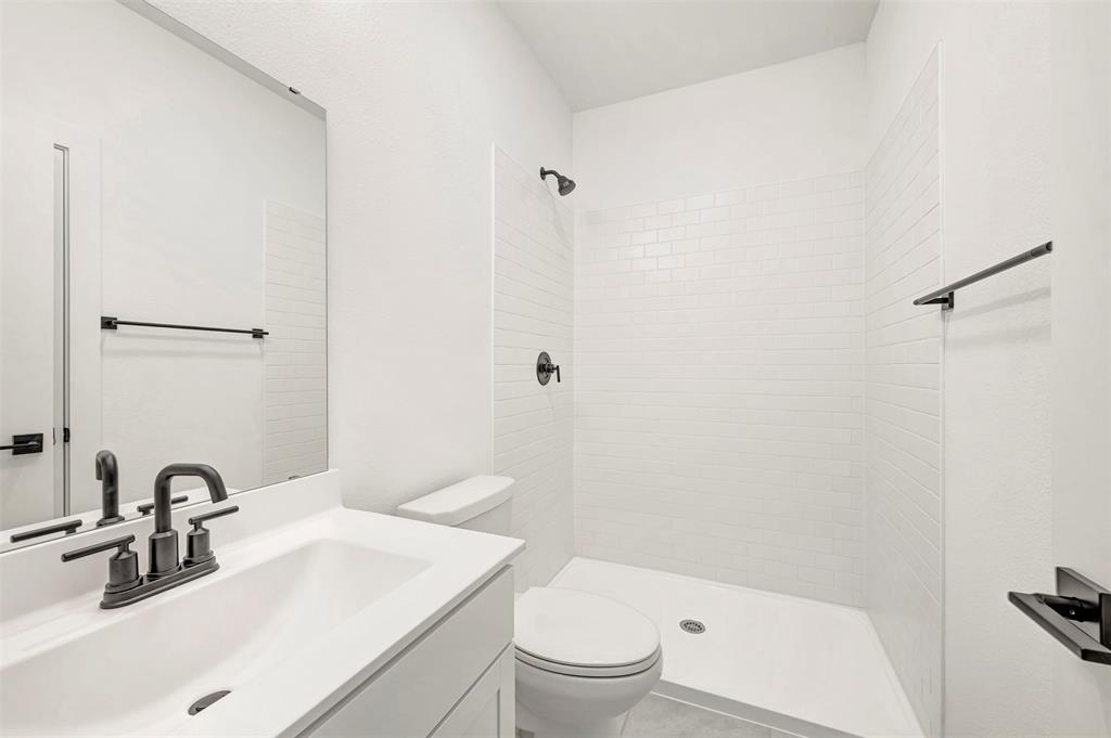 2217 Maple Ridge Drive Van Alstyne, TX 75495 - Photo 28 of 38 a bathroom with a sink toilet vanity and shower
