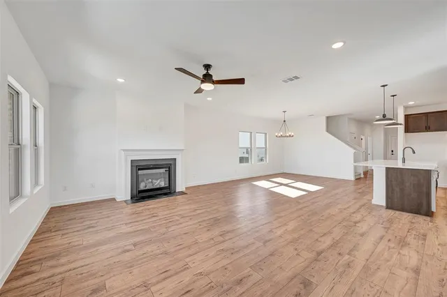 a view of empty room with wooden floor and fireplace