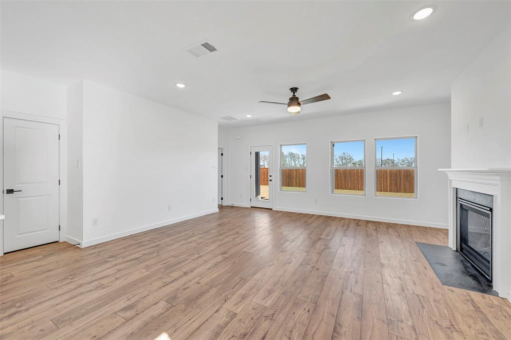 2217 Maple Ridge Drive Van Alstyne, TX 75495 - Photo 7 of 38 a view of empty room with wooden floor and fireplace