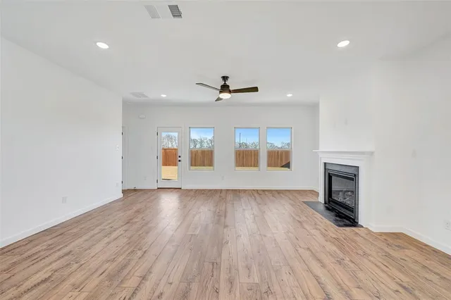 a view of empty room with wooden floor and fireplace