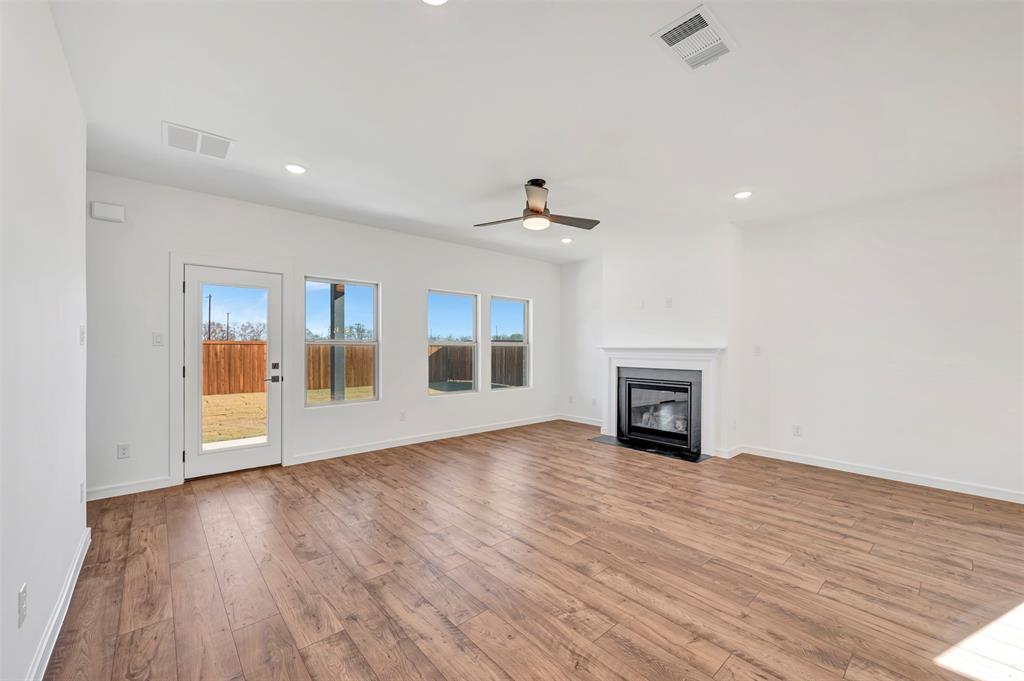 2217 Maple Ridge Drive Van Alstyne, TX 75495 - Photo 9 of 38 a view of empty room with wooden floor and fireplace