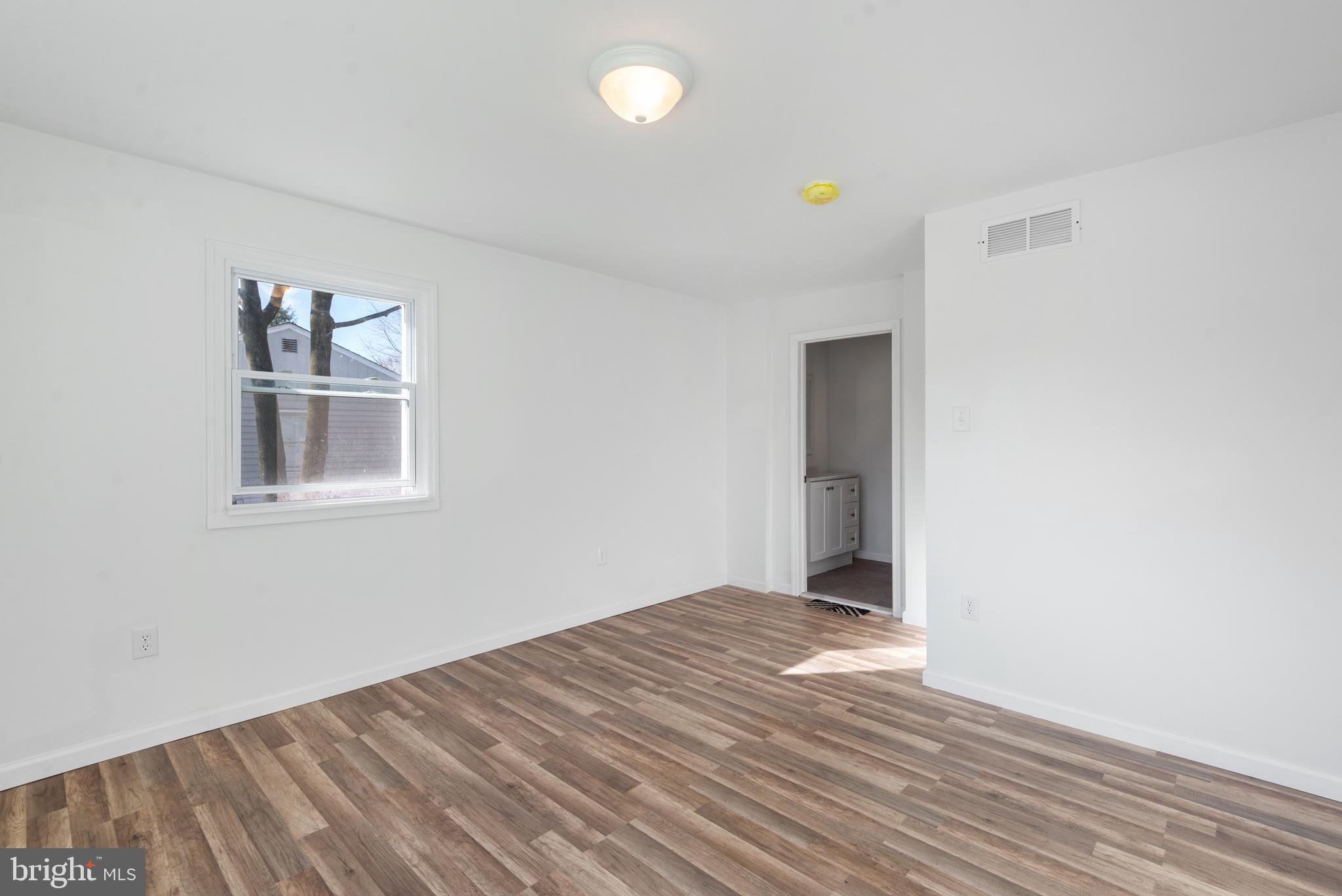 129 Marlton Road Pilesgrove, NJ 08098 - Photo 11 of 27 a view of a big room with wooden floor and windows