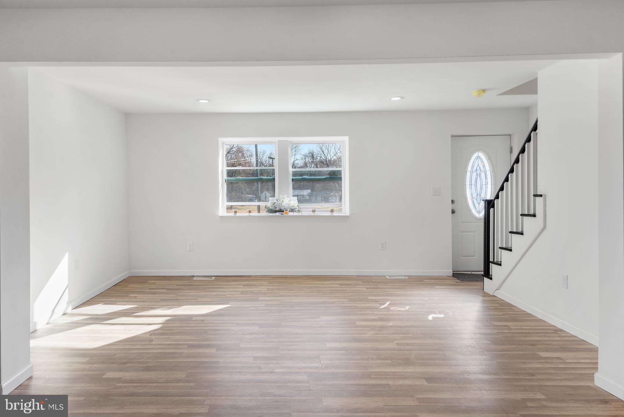 129 Marlton Road Pilesgrove, NJ 08098 - Photo 5 of 27 a view of an empty room with wooden floor and a window