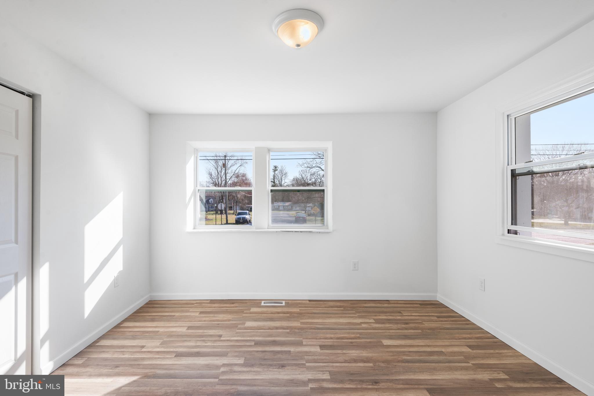 129 Marlton Road Pilesgrove, NJ 08098 - Photo 10 of 27 a view of an empty room with wooden floor and a window