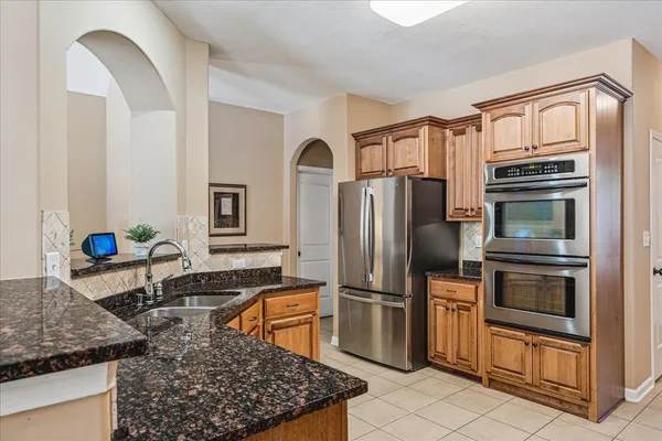 a kitchen with stainless steel appliances granite countertop a refrigerator sink and stove