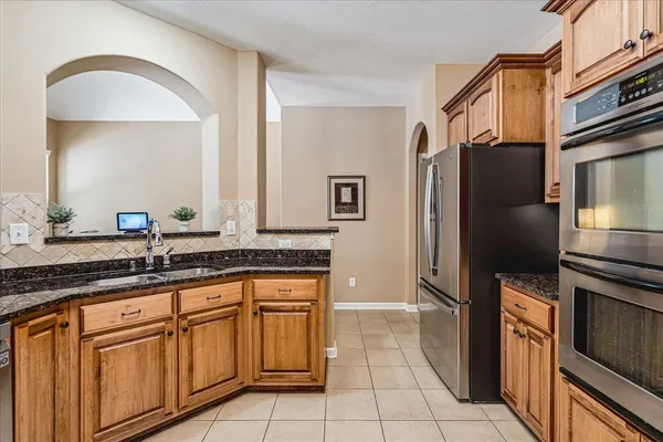a kitchen with granite countertop a refrigerator and a sink