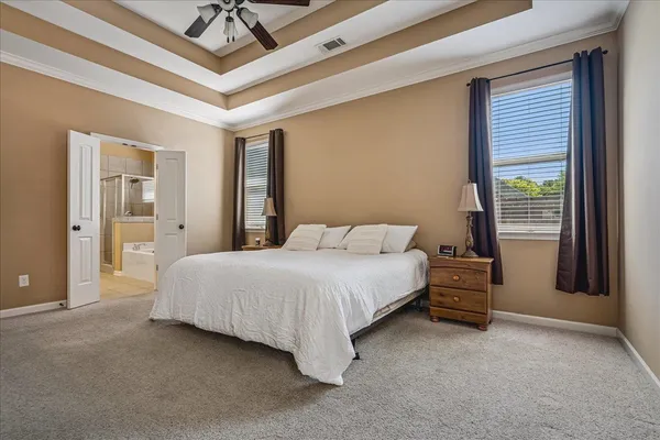 a spacious bedroom with a bed and a chandelier