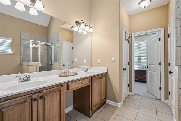 a spacious bathroom with a granite countertop sink a mirror and a shower