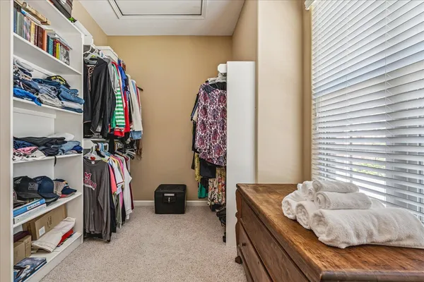 a view of walk in closet with clothes and shoes