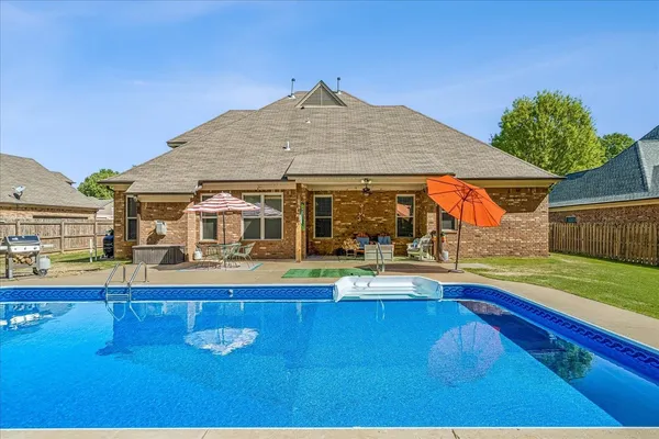 a view of a house with pool and sitting area