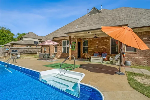 a view of a house with pool and sitting area