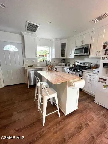 a view of kitchen with cabinets table and chairs