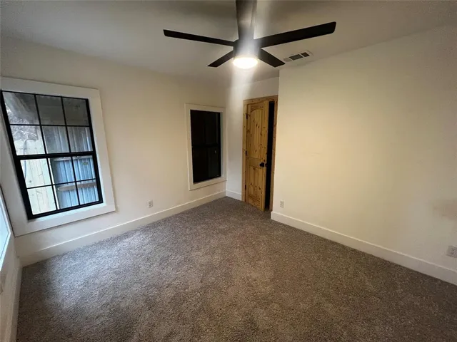 a view of a hallway with a ceiling fan and a window