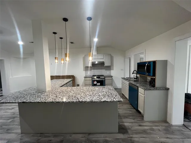 a large living room with stainless steel appliances kitchen island granite countertop furniture