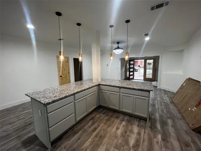 a view of an empty room and wooden floor and a window