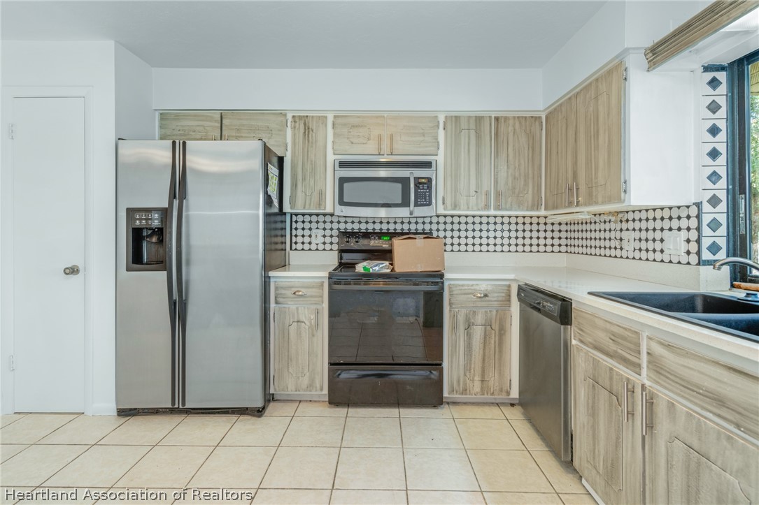 332 Oak Circle Sebring, FL 33876 - Photo 5 of 16 a kitchen with granite countertop a sink stove and refrigerator