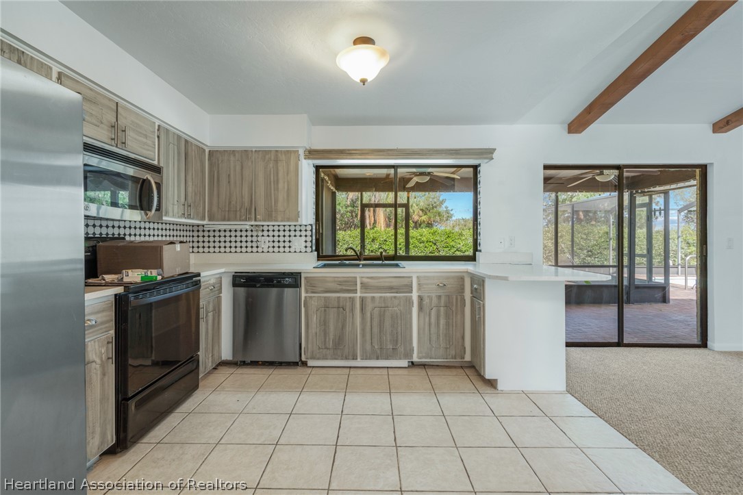 332 Oak Circle Sebring, FL 33876 - Photo 6 of 16 a kitchen with stainless steel appliances a stove a sink and a refrigerator