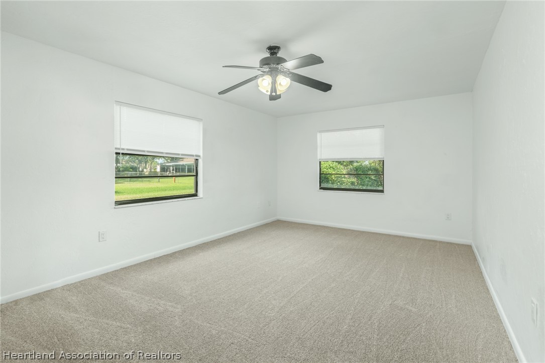332 Oak Circle Sebring, FL 33876 - Photo 8 of 16 an empty room with windows and fan