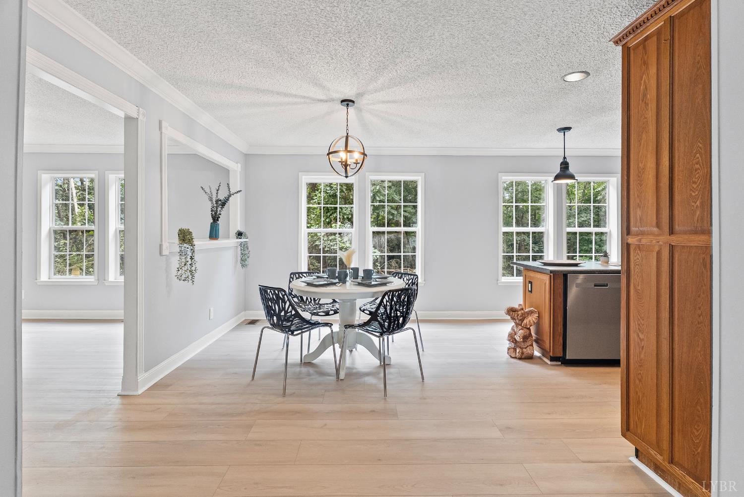 3701 Bethany Road Rustburg, VA 24588 - Photo 10 of 55 a dining room with wooden floor a chandelier a glass table and windows