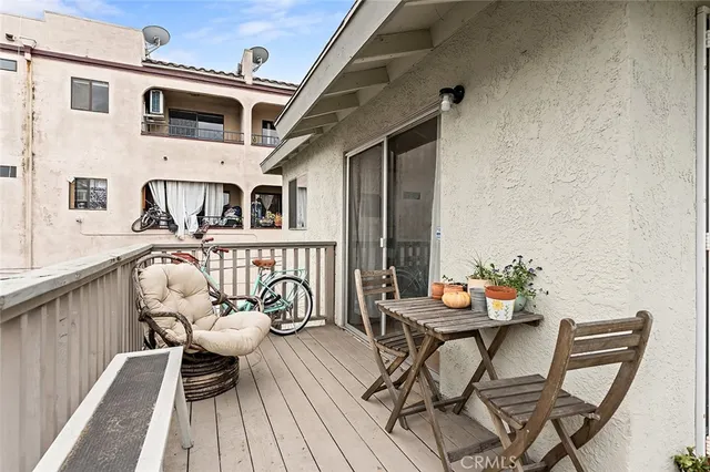 a balcony with wooden floor stairs and furniture