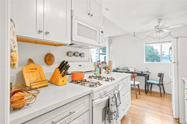 a kitchen that has a lot of cabinets and wooden floor