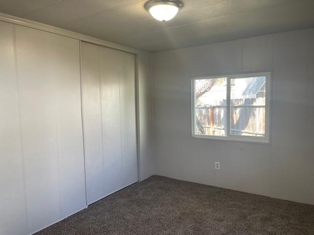 14610 Mono Way, Unit 7 Sonora, CA 95370 - Photo 15 of 15 Unfurnished bedroom with a closet and dark carpet