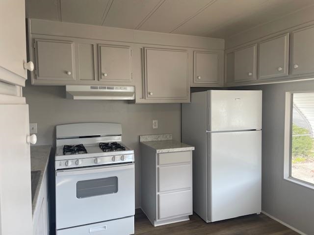 14610 Mono Way, Unit 7 Sonora, CA 95370 - Photo 3 of 15 Kitchen with white appliances, light countertops, under cabinet range hood, and dark wood-style floors