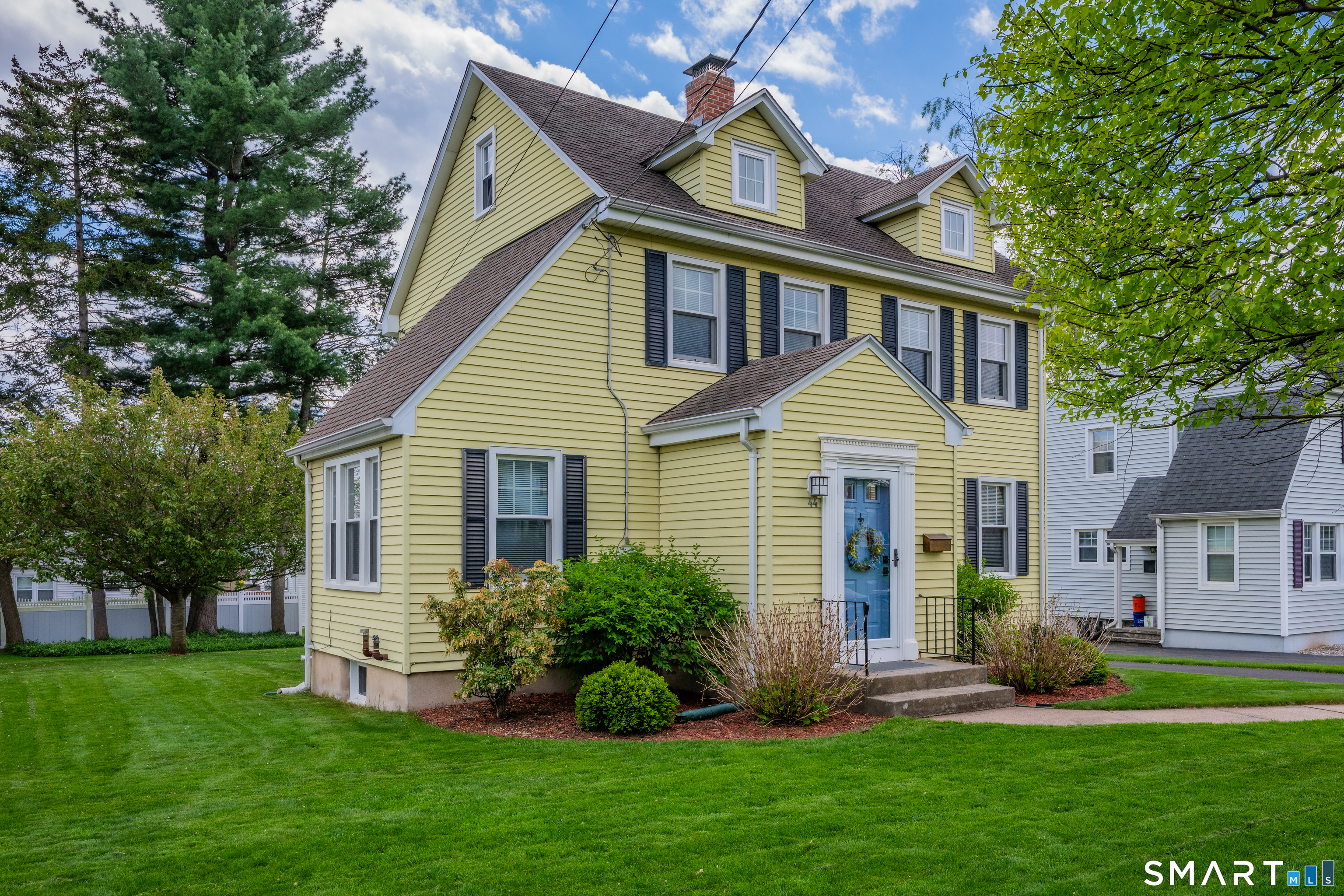 44 Beverly Road Wethersfield, CT 06109 - Photo 4 of 31 a front view of a house with a garden and plants