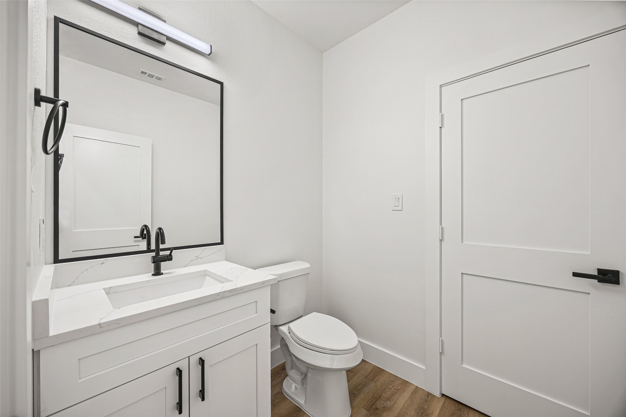 1807 Waco Street Dayton, TX 77535 - Photo 10 of 26 Contemporary vanity with quartz countertop, framed mirror, and matte black fixtures.