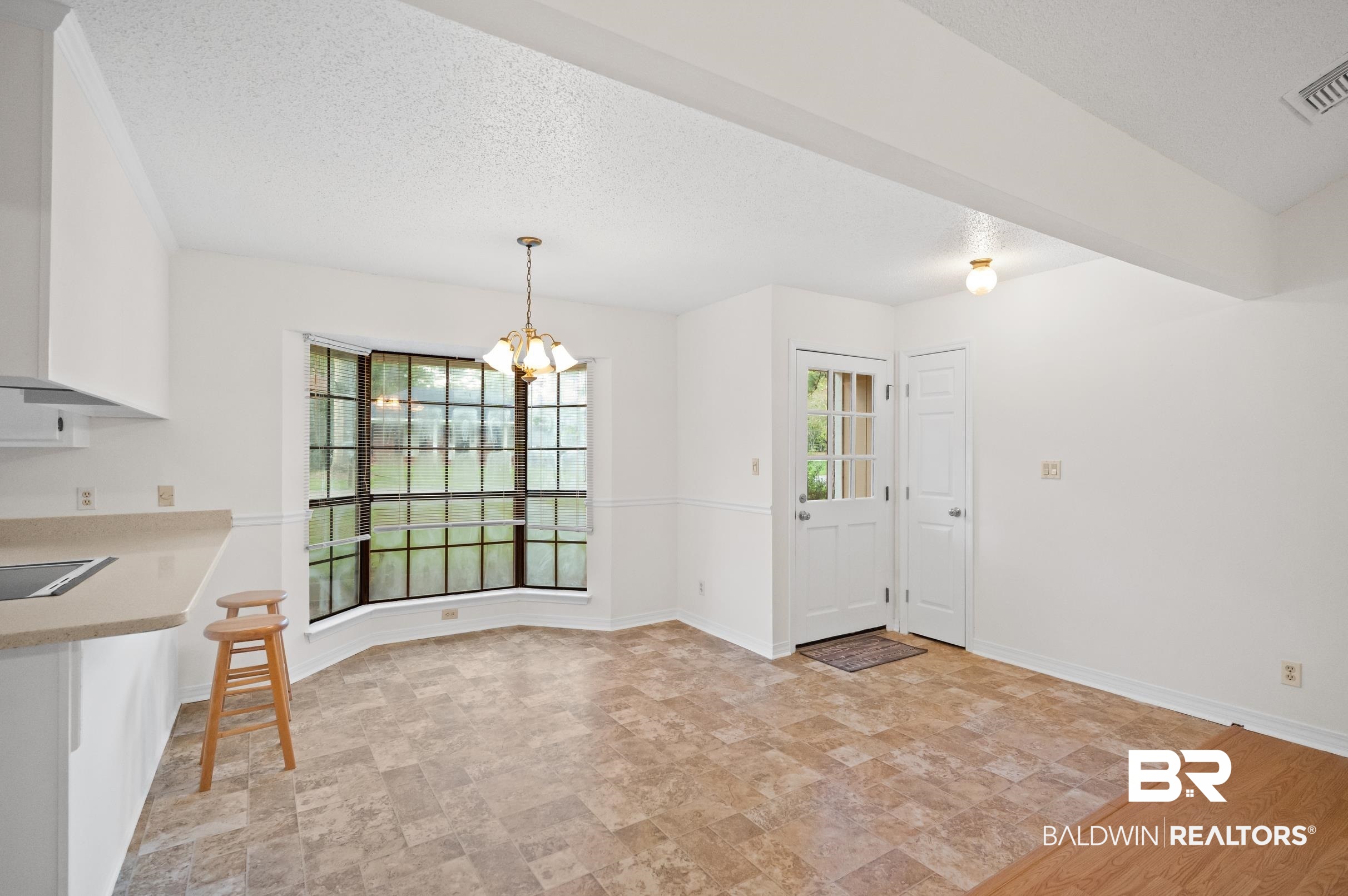 128 Dunbar Loop Daphne, AL 36526 - Photo 9 of 39 Unfurnished dining area featuring a textured ceiling, a chandelier, and light hardwood / wood-style floors