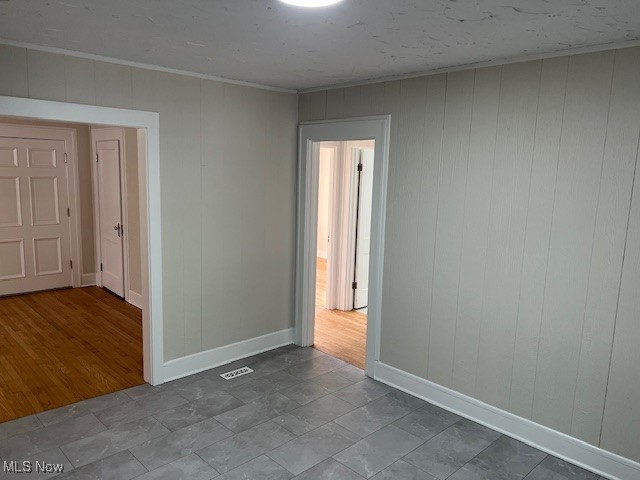 1356 Plainfield Road Cleveland, OH 44121 - Photo 8 of 12 Unfurnished room with wooden walls and crown molding