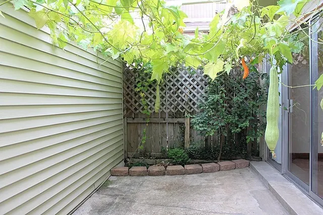 a view of a backyard with plants and brick wall