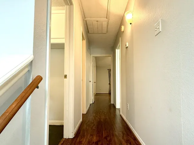 a view of a hallway with wooden floor and staircase