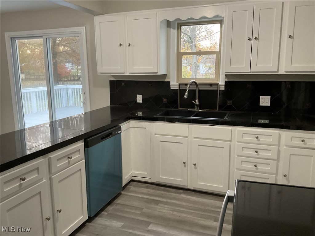 Kitchen featuring range, white cabinetry, tasteful backsplash, dishwashing machine, and dark wood finished floors