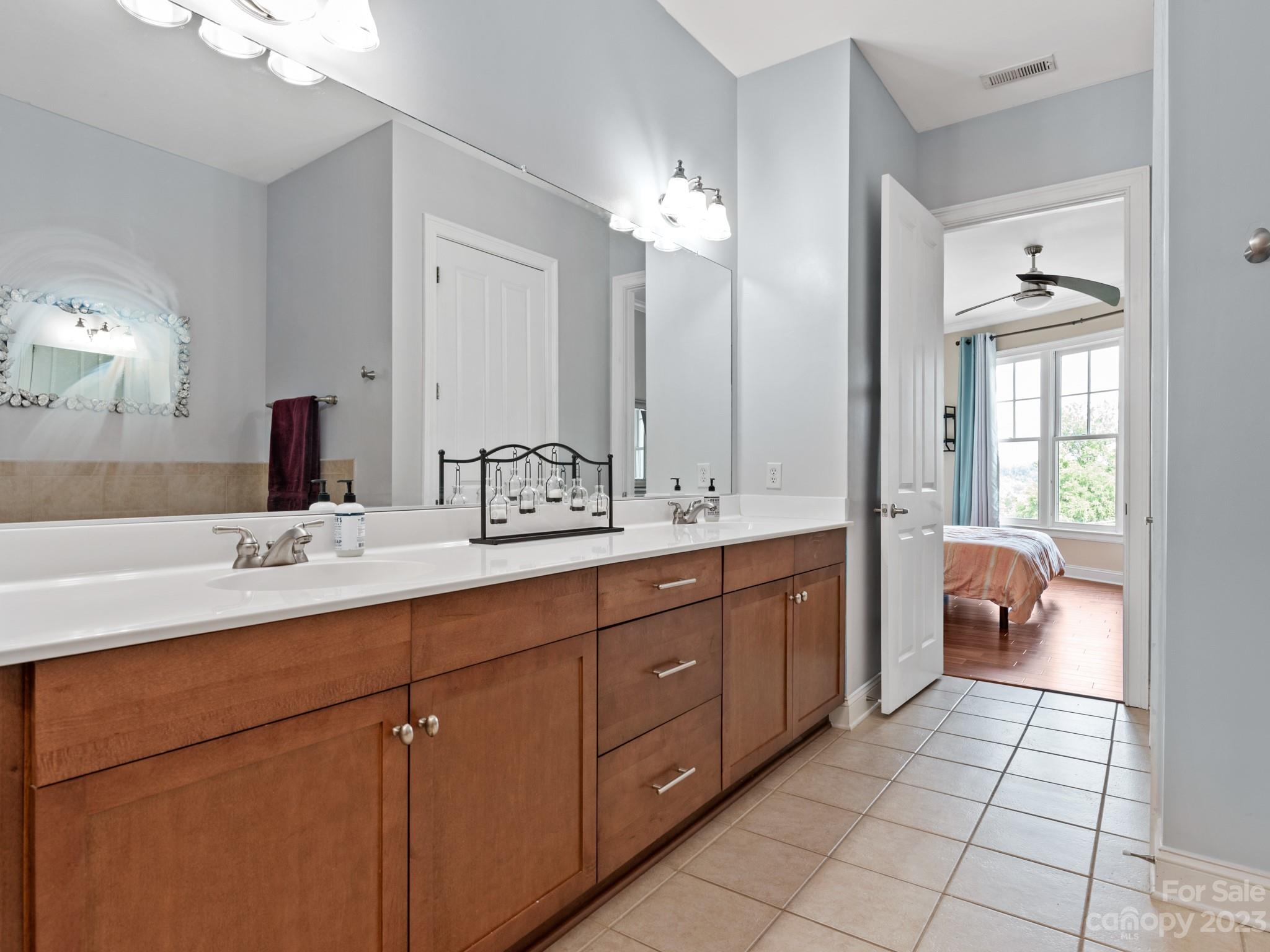 5425 Closeburn Road, Unit 201 Charlotte, NC 28210 - Photo 11 of 35 a spacious bathroom with a double vanity sink a mirror and a bathtub