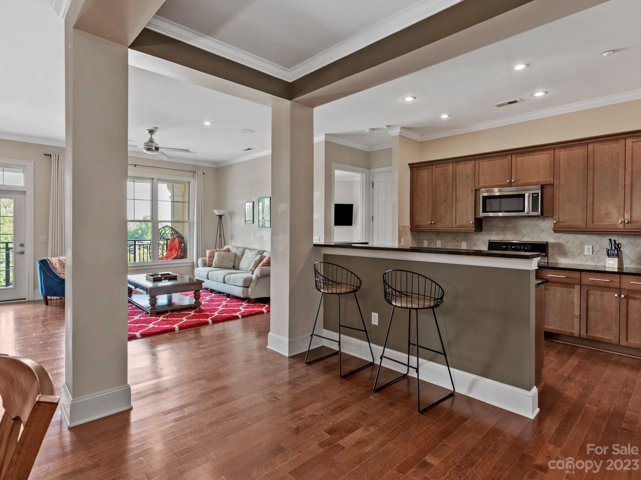 5425 Closeburn Road, Unit 201 Charlotte, NC 28210 - Photo 2 of 35 a kitchen with kitchen island granite countertop wooden floors and view living room