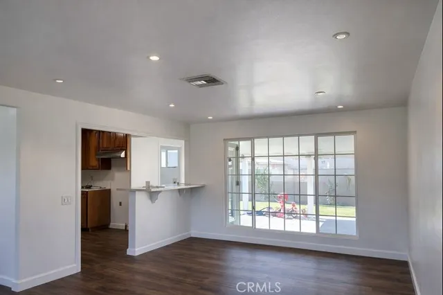 a view of a kitchen with wooden floor and a window