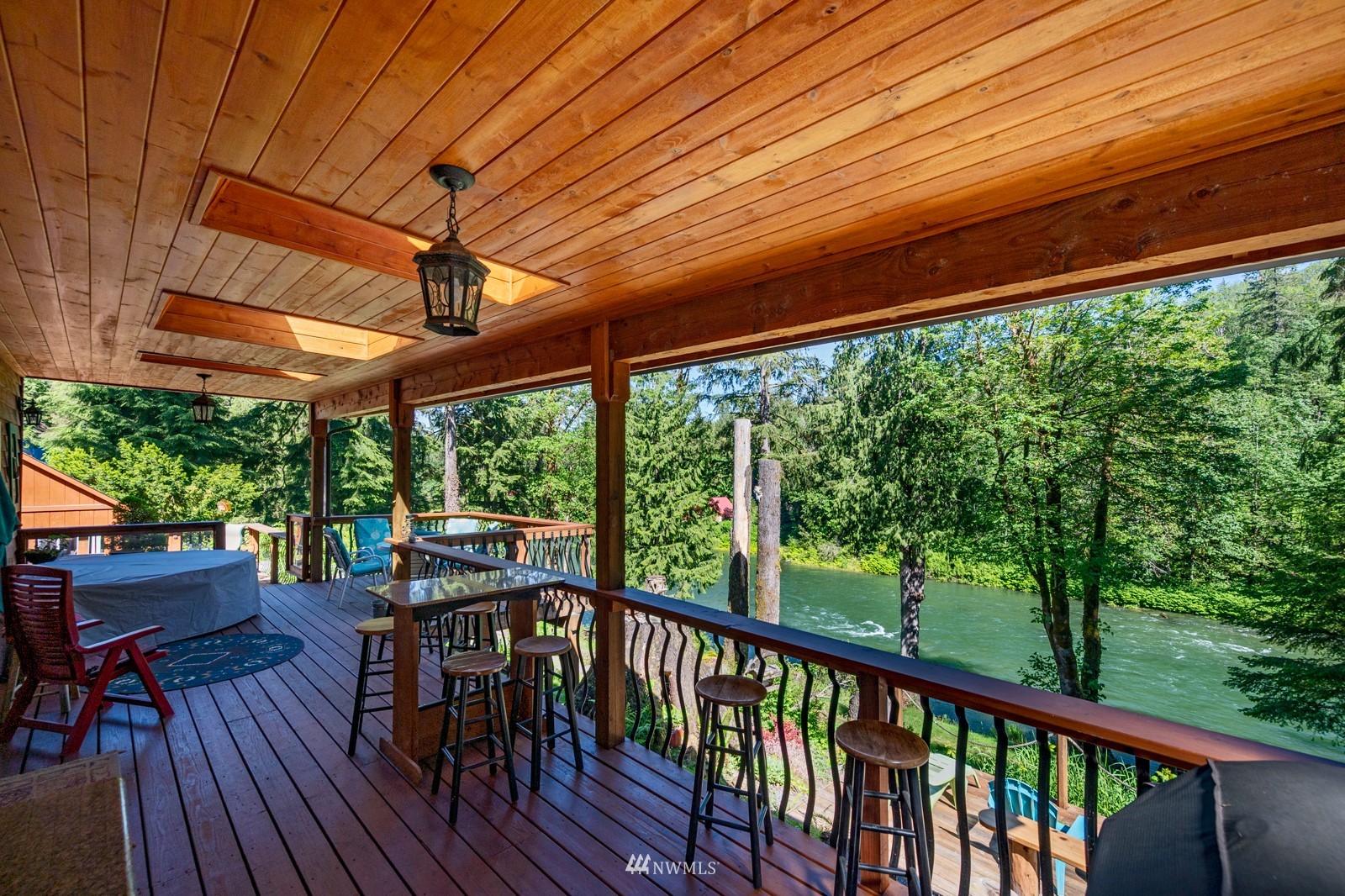 52133 South Riverside Road Gold Bar, WA 98251 - Photo 14 of 40 a view of a patio with table and chairs under an umbrella with a small yard
