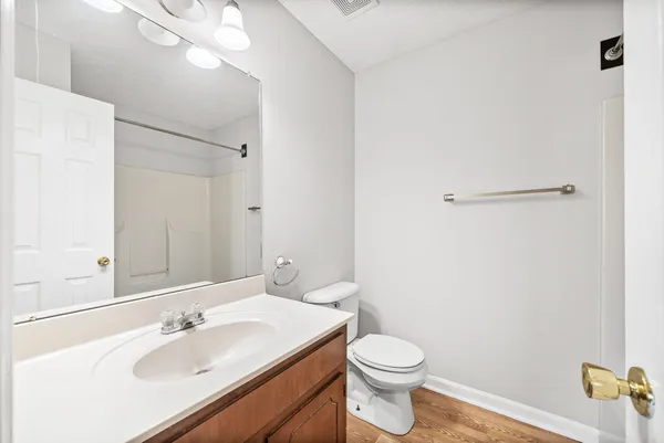 an empty room with ceiling fan and windows
