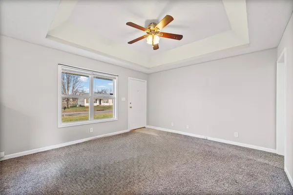 an empty room with fan and windows